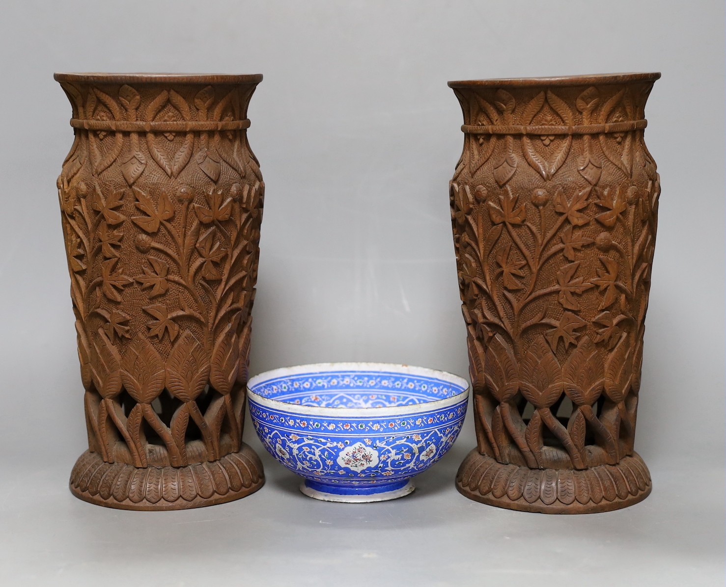 A pair of Indian carved wood vases, 22.5cm high, and a Persian blue enamel bowl (3)